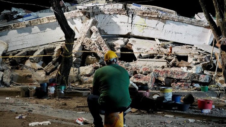 Un uomo siede vicino alle macerie dell edificio Torres de Limonar dopo il terremoto a Cali in Colombia