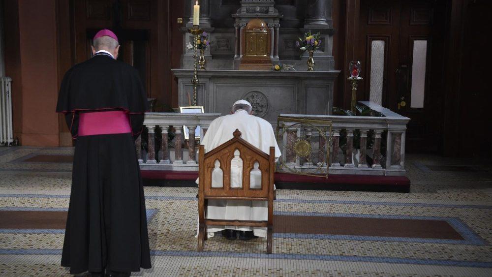 papa prega davanti alla candela per le vittime degli abusi